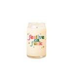 Can glass candle with text that reads "festive as fuck" in multi-color font on the front; text is surrounded by gold minimalist sparkle-stars.