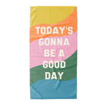 All caps "today's gonna be a good day" text with colorful wavy rainbow beach towel.