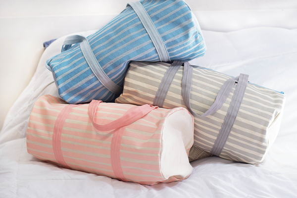 three cute canvas duffel bags. one with peach stripes, one with gray stripes, one with beach wash denim stripe