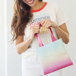 Cute rainbow ombre print small tote bag being held by woman in front of a white background.