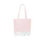 A cute tote bag with long shoulder strap in a blush pink with white paint splatter detail along the bottom.