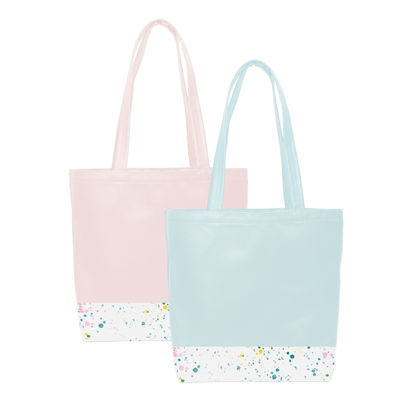 Two cute tote bags; One blue and one pink, with a long shoulder strap and white paint splatter detail along the bottom. 