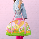 girl holding large tote with pink straps and colorful floral print