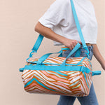 Girl walking with the Wild Stripe patterned traveler over her shoulder.