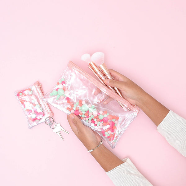 a girl holding all the things pom poms with makeup brushes