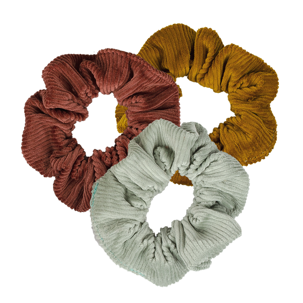 Three corduroy scrunchies in tan, light blue, and a dusty pink.