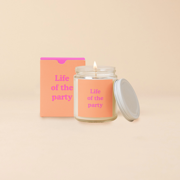 A 8 oz. candle jar with lid, with a coral decal on it "Life of the party" printed on.