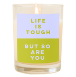 A candle with a decal that says, "Life is tough but so are you." Top half is a a powder blue color and bottom half of decal is an olive green color