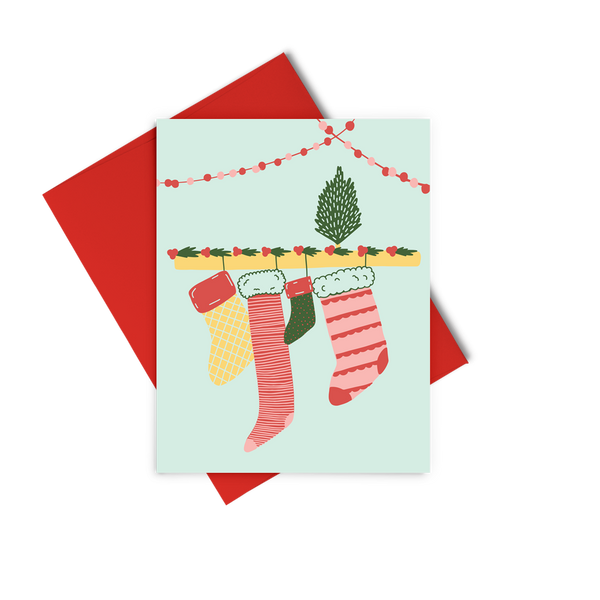 a greeting card with a drawing of four different size Christmas stockings hanging on a ledge with tinsel.