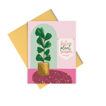 A pink and green greeting card that says "festive plant season" and has an illustration of a houseplant with colorful ornaments.