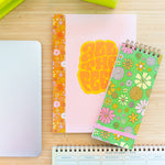 desk set up with different notebooks, lime green stapler and tape dispenser