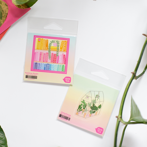 A multicolored bookshelf and potted plant sticker along with a ombre green house sticker with plants inside. Both stickers are in front of a white background.