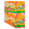 puffy quilted blanket with big colorful flowers and rainbow swirls with a solid color on the backside