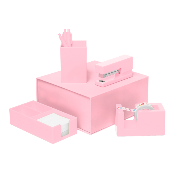 Blush Pink desk set including a stapler, tape dispenser, utility tray, and pen cup with three pink pens all stacked on top of a matching box.