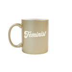 Feminist Sand Carved Metallic Mug is a funny coffee mug with engraved lettering in gold.