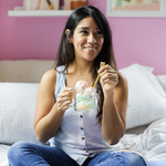 a girl holding a cute glass mug that says cluster fuck in light blue with white daisies