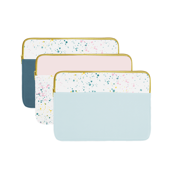 Three laptop sleeves with gold zippers; one powder blue splatter, one blush pink splatter, and one spruce green splatter.