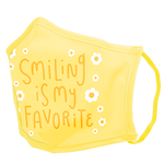 A yellow facemask with white daisies and yellow script saying "smiling is my favorite."