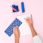 Canvas Pencil Pouch in navy with white triangles and peach zipper next to a navy blue desk set and a planner