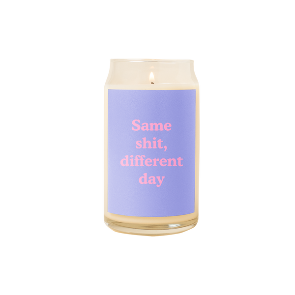 A 16 oz. candle with a light blue decal on it with the phrase "Same shit, different day" printed on.