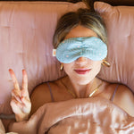 Mint colored weighted pillow with a white outline silhouette drawing of a woman's face with blush colored cheeks pattern