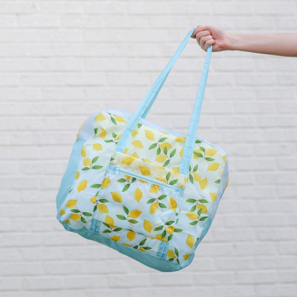 a girl holding a ripstop bag with blue straps and yellow lemons