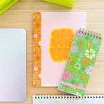 desk set up with different notebooks, lime green stapler and tape dispenser