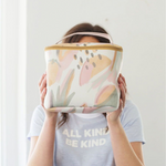 Brunette girl holding a cute toiletries bag in an abstract fruits pattern.