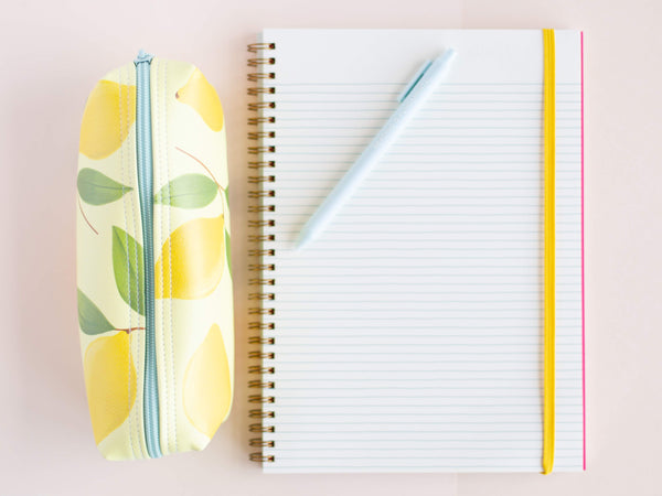 a lemons jitterbug next to a notebook and a jotter