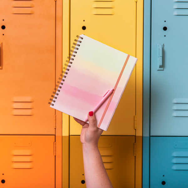 Multi-colored pastel goal setting planner with TOOT pen in front of multi-colored lockers 